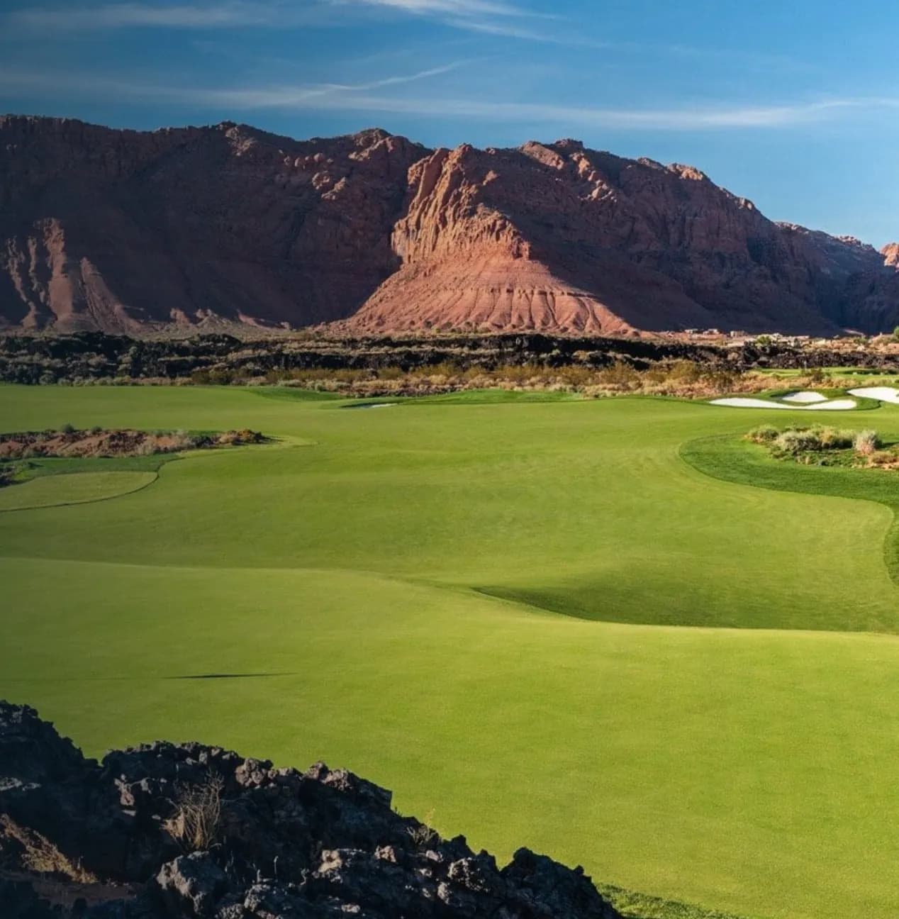 Campo de golf de Utah entre lava negra y montañas de roca roja